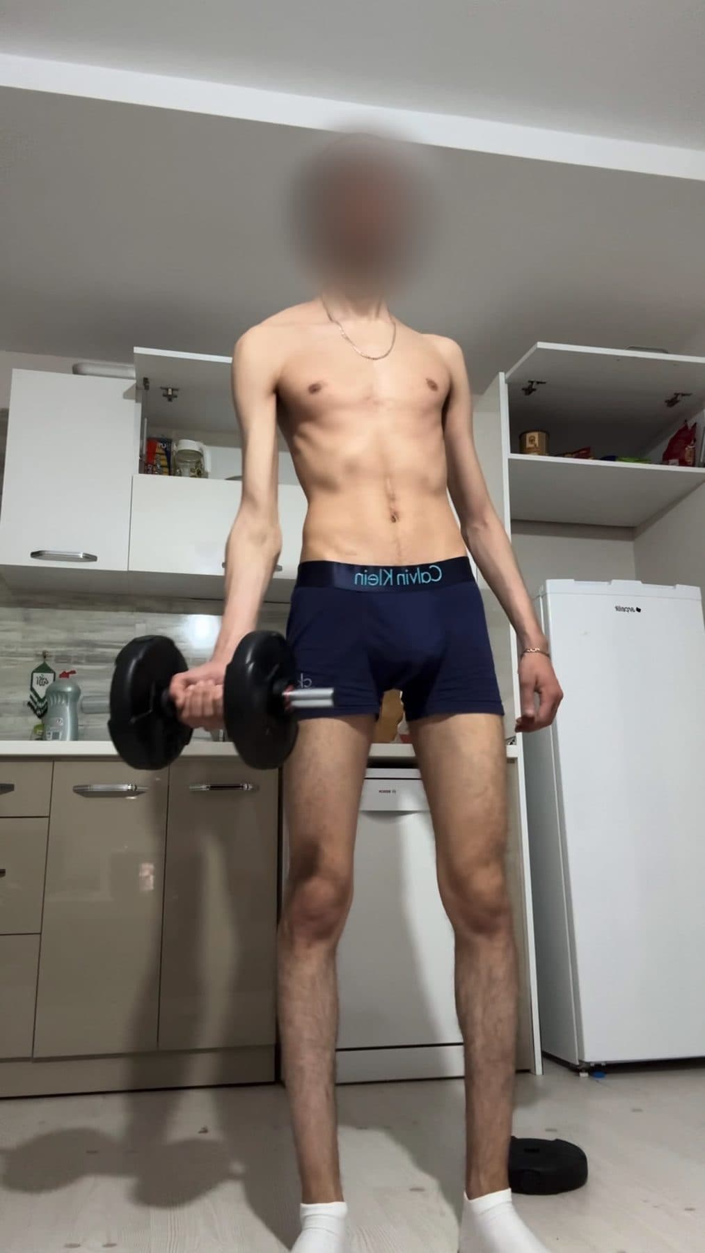 Day 1 in the kitchen, very thin, a dumbbell in each hand